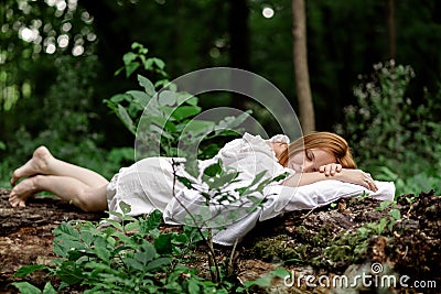 A woman sleeps in the woods on a pillow. Healthy, sound sleep concept. Rest, relaxation in nature Stock Photo