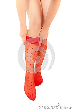 Woman with slender legs pulling up red pantyhose Stock Photo