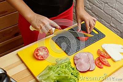 Woman slice tomato. Cooking from fresh vegetables Stock Photo