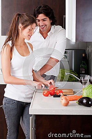 Woman slicing tomatoes with her boyfriend Stock Photo