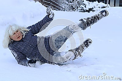 A woman slips on a snowy road Stock Photo