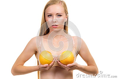 Woman small boobs holds big orange fruits Stock Photo