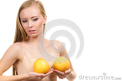 Woman small boobs holds big orange fruits Stock Photo