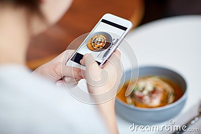 Woman with smartphone photographing food at cafe Stock Photo