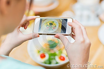 Woman with smartphone taking picture of food Stock Photo