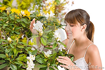 Woman smelling blossom of Rhododendron flower Stock Photo