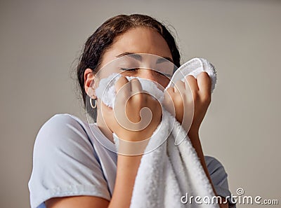 Woman smelling a clean towel after doing laundry at her home, hotel or resort while spring cleaning. Housekeeping, maid Stock Photo