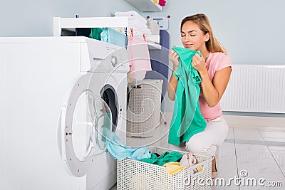 Woman Smelling Clothes After Washing Stock Photo