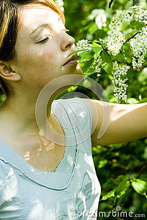 Woman smells flowering tree Stock Photo