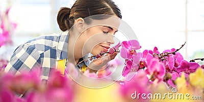 Woman smells the flowers in garden, fragrance of orchids Stock Photo