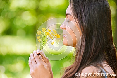 Woman smells yellow florets Stock Photo