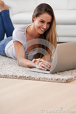 Woman, smile and laptop on floor with reading for blogging, communication and email on mat in living room of home Stock Photo