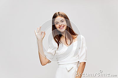 Woman smiling gesturing to another white dress studio cropped view Copy Space Stock Photo