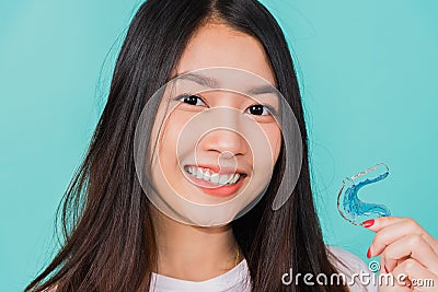 Woman smiling holding silicone orthodontic retainers for teeth Stock Photo