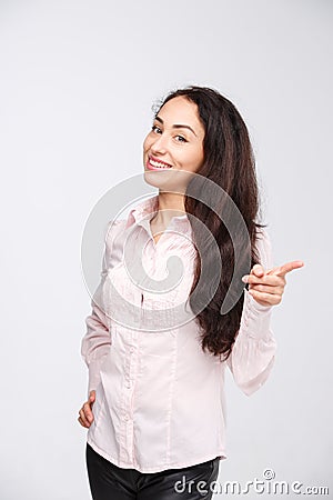 Woman smiling pointing up showing copy space. Beautiful young professional businesswoman isolated on white background Stock Photo