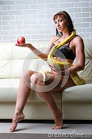 Woman with a snake holding red apple Stock Photo