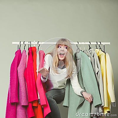 Woman sneaking among clothes in mall or wardrobe. Stock Photo