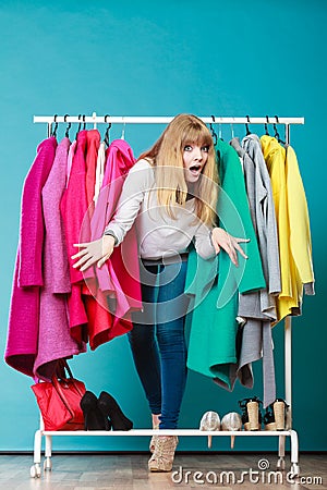Woman sneaking among clothes in mall or wardrobe. Stock Photo