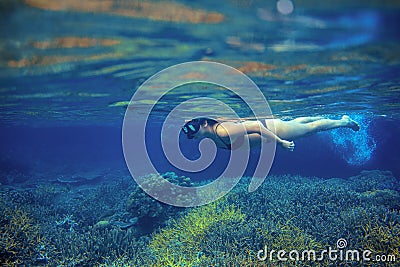 Woman snorkel in coral reef. Young girl in bikini swimming underwater. Snorkeling in tropical sea Stock Photo