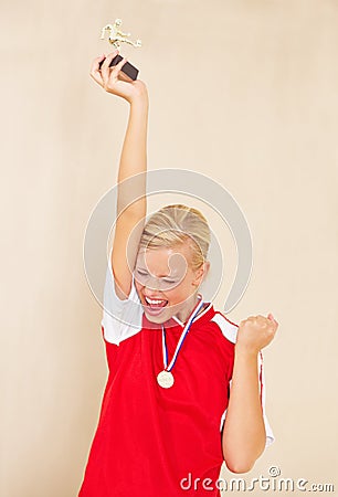 Woman, soccer player and trophy or a winner celebrate on a plain background for football achievement. A young female Stock Photo