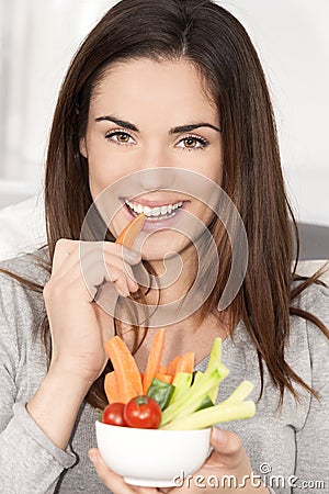 Woman on sofa eating vegetable salad Stock Photo