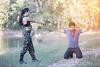 Woman soldier with a pistol arrested the culprit Stock Photo