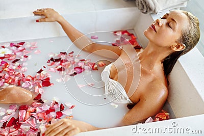 Woman Spa Flower Bath. Aromatherapy. Relaxing Rose Bathtub. Beauty Stock Photo