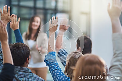 Woman speaker at conference, group of people with hands up for question or answer at training presentation or meeting Stock Photo