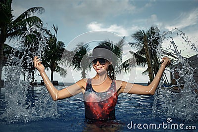 Woman splashing in blue swimming Stock Photo