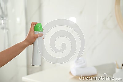 Woman spraying air freshener in bathroom Stock Photo
