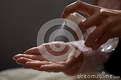 Woman spraying antiseptic onto hand against blurred background, closeup Stock Photo