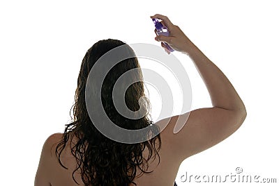 Woman spraying hair with styling product. Stock Photo