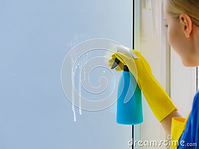 Woman spraying window cleaning detergent Stock Photo