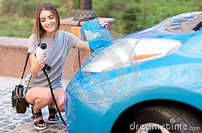 Woman squatting and looking at power connector Stock Photo