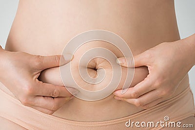 Woman squeezes belly fat Stock Photo