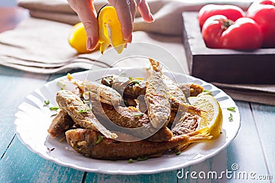 Woman squeezes juice from a lemon on a roasted mushroom Stock Photo
