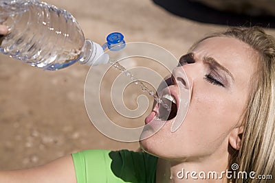 Woman squirting water from bottle Stock Photo