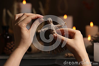 Woman stabbing voodoo doll with pin in dark, closeup. Curse ceremony Stock Photo