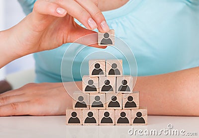 Woman stacking wooden team blocks at table Stock Photo