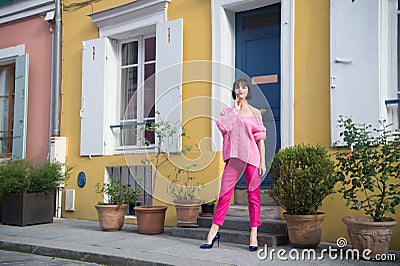 Woman stand in high heel shoes in paris, france, vacation. Woman in pink sweater, trousers on street, fashion. Beauty, look, makeu Stock Photo