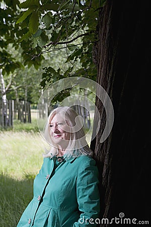 Woman Standing Beneath Tree Stock Photo