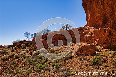 Woman standing at the foot of towering red rocks in the Western Australian outback Stock Photo