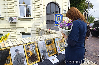 Woman standing in front of the Wall of Remembrance with portraits of soldiers and mourning Editorial Stock Photo