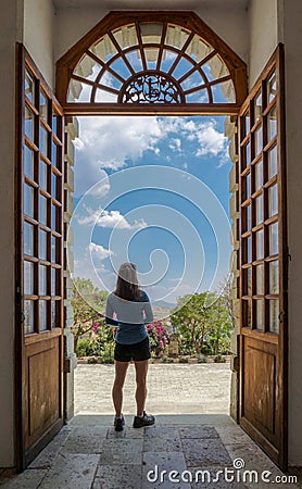 Woman standing gazing out doorway Stock Photo