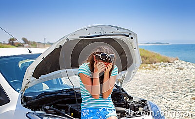 Woman is standing near broken car Stock Photo