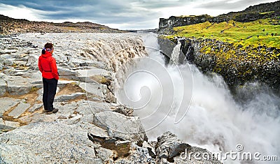 Woman standing near famous Dettifoss waterfall in Vatnajokull National Park, Iceland Stock Photo