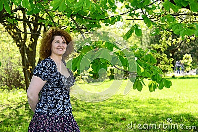 Woman standing in park near the chestnut Stock Photo