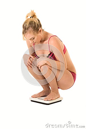 Woman standing on scales checking her weight Stock Photo