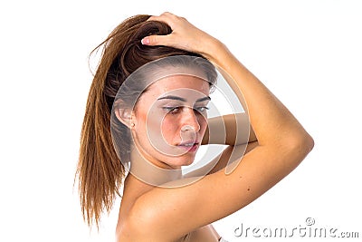 Woman standing sidewise and fixing hair Stock Photo