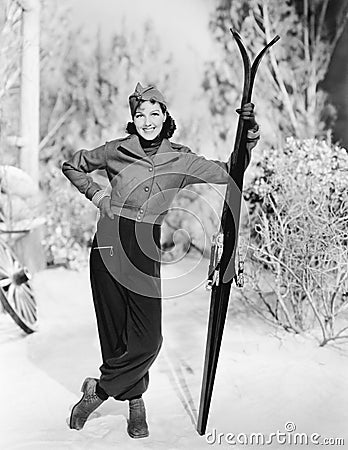 Woman standing in the snow with her skies in hand Stock Photo